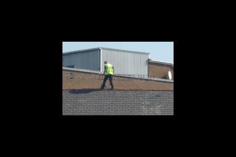 Man on roof carrying ladder